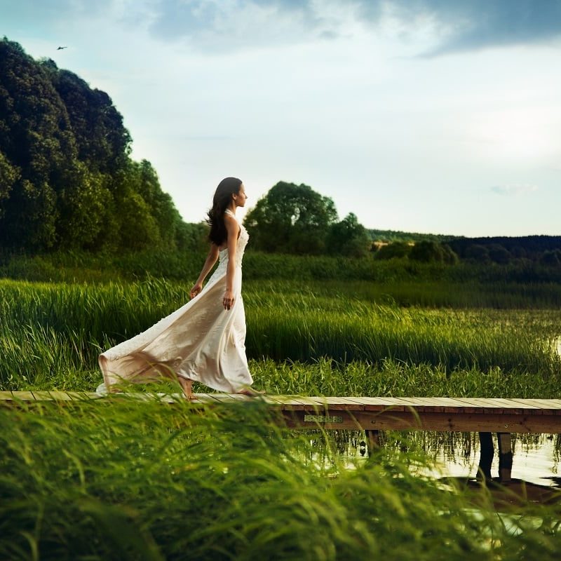 Beautiful vacation Beautiful woman in white dress walking down the pier
